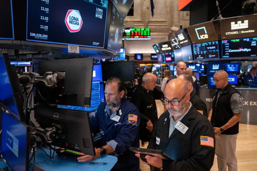 Traders work on the floor as markets assess July inflation and Federal Reserve policy