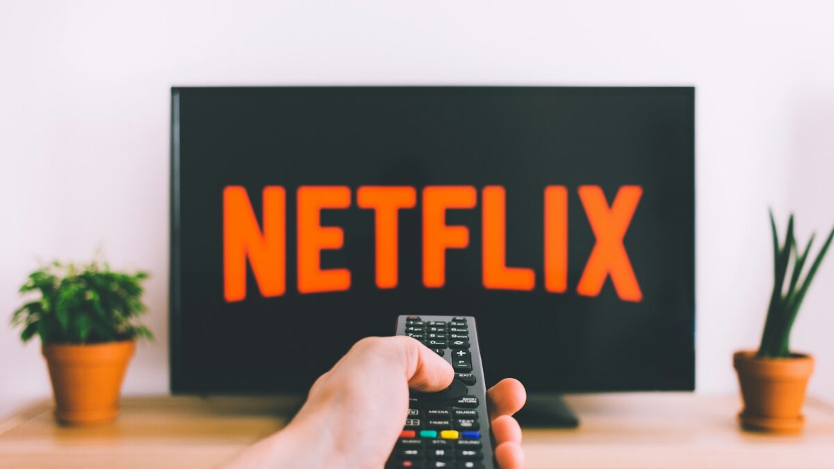 A person choosing a film to watch on a television