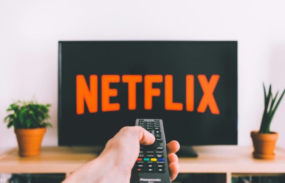 A person choosing a film to watch on a television